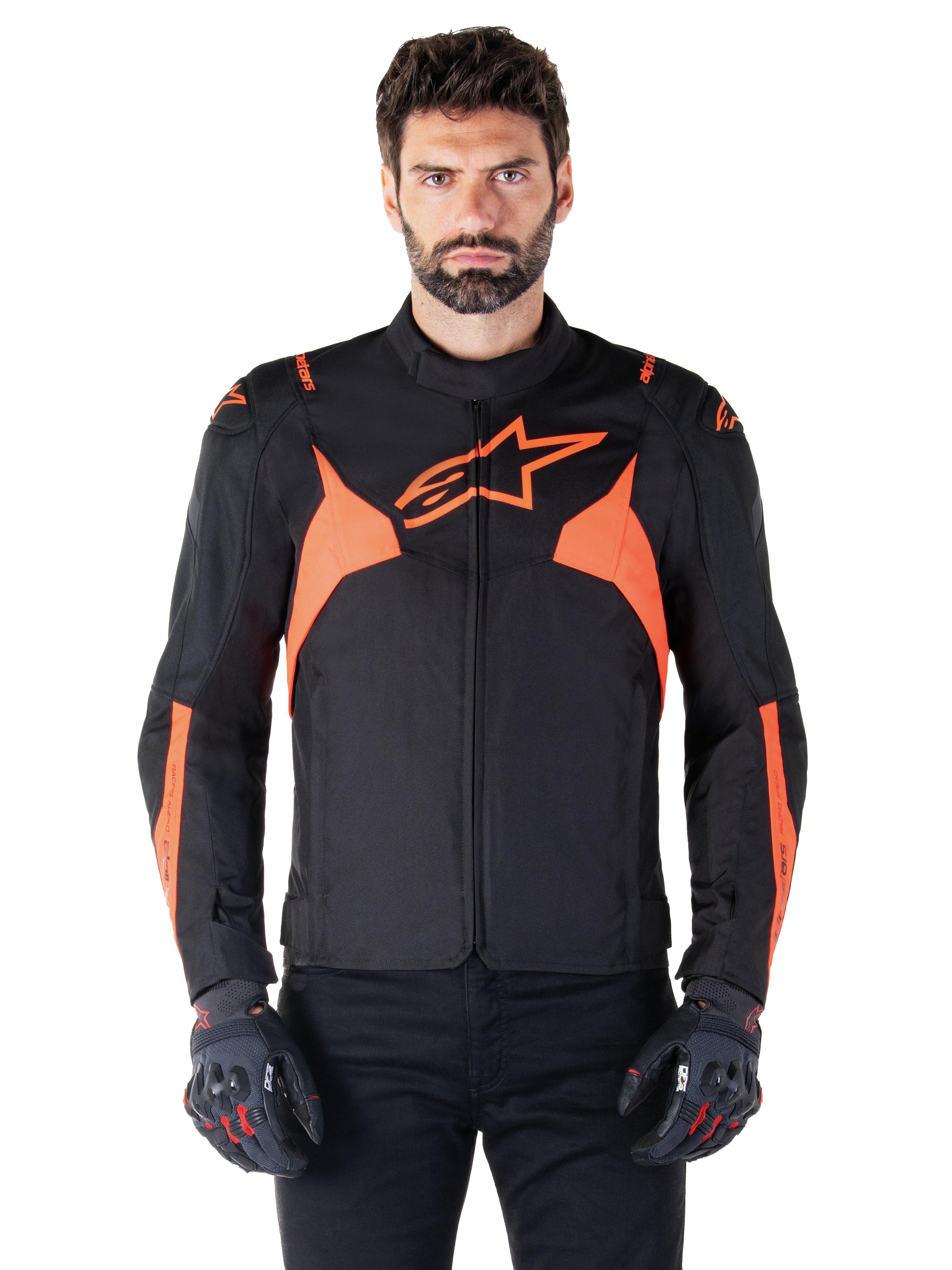 Giacca impermeabile Alpinestars T-Jaws V4, giacca sportiva da moto, nero e rosso fluo, con accenti neon e un prominente logo a stella sul petto, indossata da un modello uomo con guanti da moto neri, design in tessuto elegante d'ispirazione racing