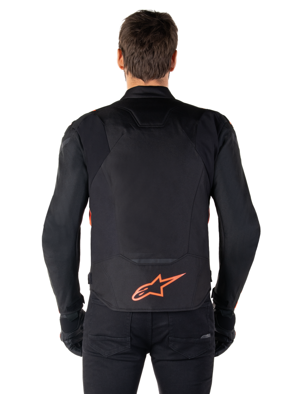 Giacca impermeabile Alpinestars T-Jaws V4, vista posteriore, nero con rosso fluo, con logo Alpinestars rosso sulla parte bassa della schiena, struttura in tessuto tecnico, indossata con pantaloni e guanti neri per un look da guida sportiva completo