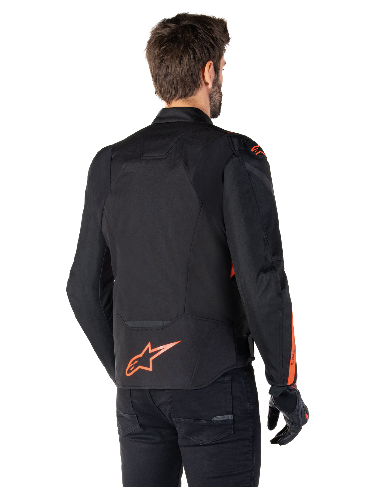 Modello che indossa la giacca Alpinestars T-Jaws V4 Waterproof vista da dietro, nera con accenti rosso fluo, con un logo rosso fluo sulla parte bassa della schiena e accenti su spalle e maniche, abbigliamento sportivo da moto.