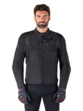 Giacca impermeabile Alpinestars T-Jaws V4, giacca da moto sportiva nera, indossata da un uomo con guanti neri e dettagli rossi, spalle e braccia rinforzate, design elegante con logo discreto sul petto, abbigliamento da moto in tessuto per tutte le stagioni