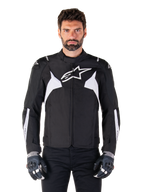 Giacca impermeabile Alpinestars T-Jaws V4, giacca da moto sportiva in tessuto da uomo, nero e bianco, logo stella bianco sul petto, dettagli bianchi sulle spalle e strisce bianche sugli avambracci, colletto alto, vestibilità atletica per la guida su strada
