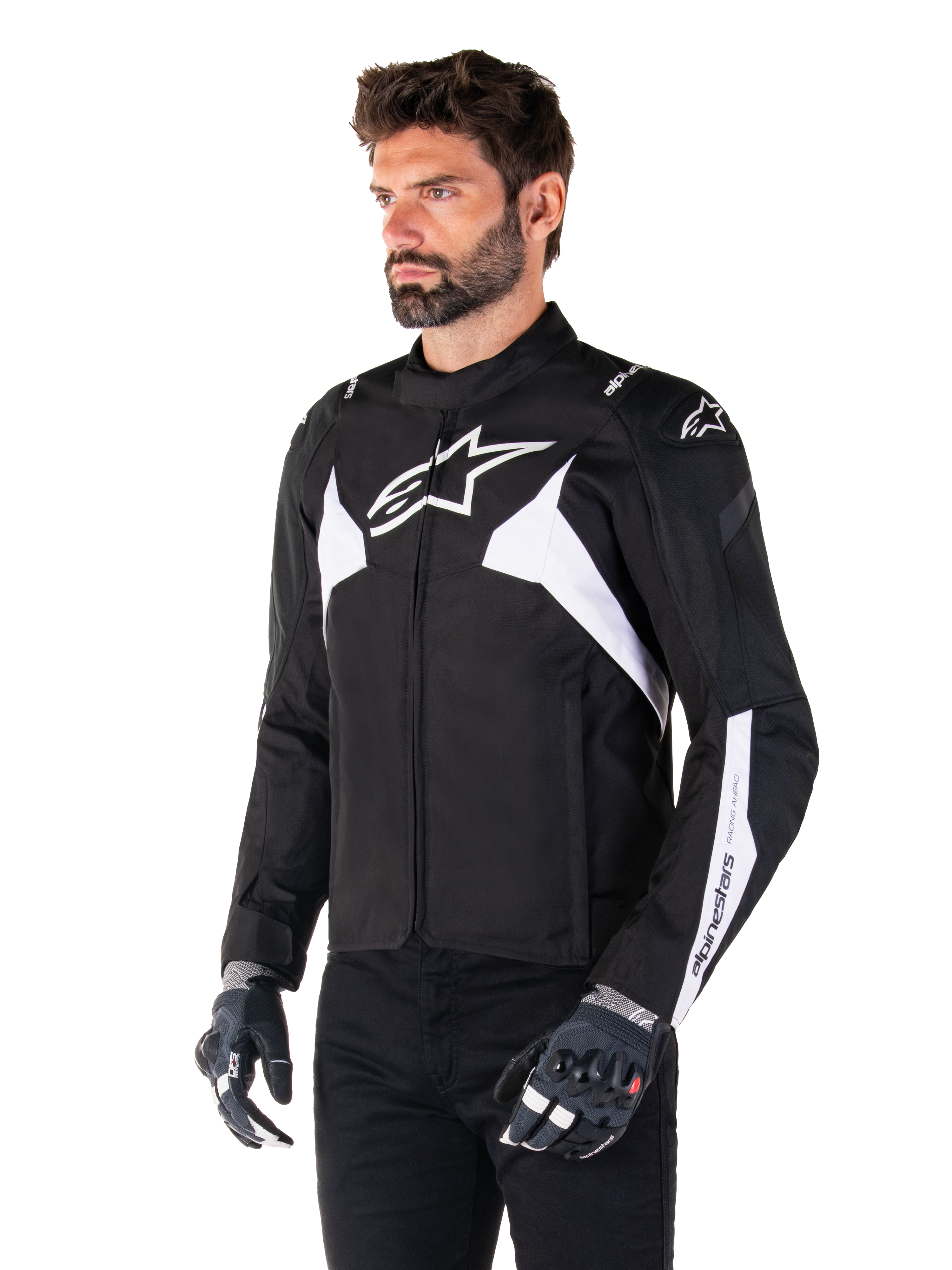 Giacca Alpinestars T-Jaws V4 Waterproof, nero e bianco, indossata da un modello con guanti da moto, con loghi Alpinestars e dettagli bianchi in evidenza, giacca da moto in tessuto con vestibilità sportiva per la guida su strada