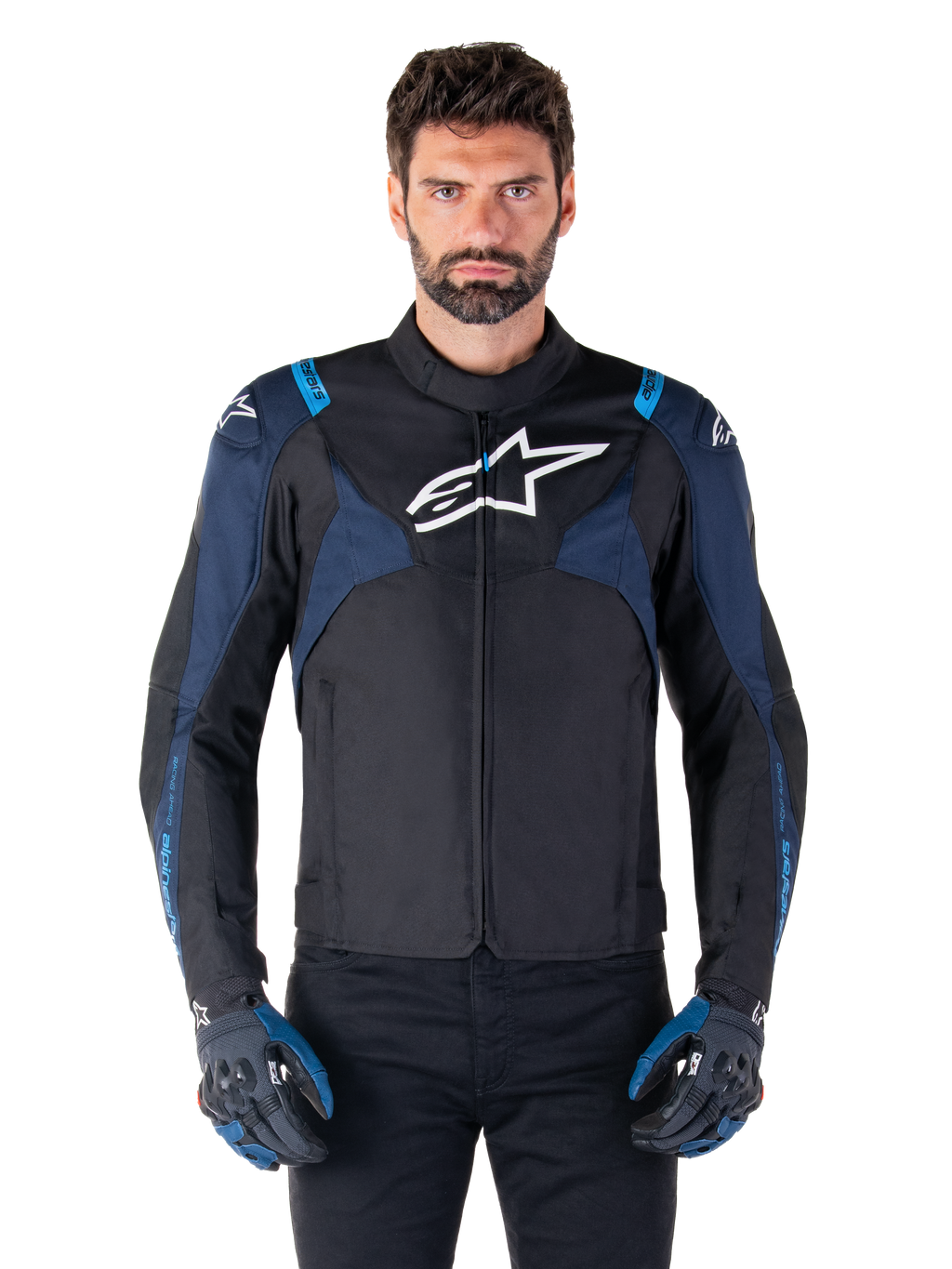 Giacca Alpinestars T-Jaws V4 Waterproof, giacca da moto, nero e blu scuro con accenti blu Blithe, logo bianco sul petto, scritte blu sulle spalle, indossata con guanti abbinati, abbigliamento tecnico da moto in tessuto impermeabile