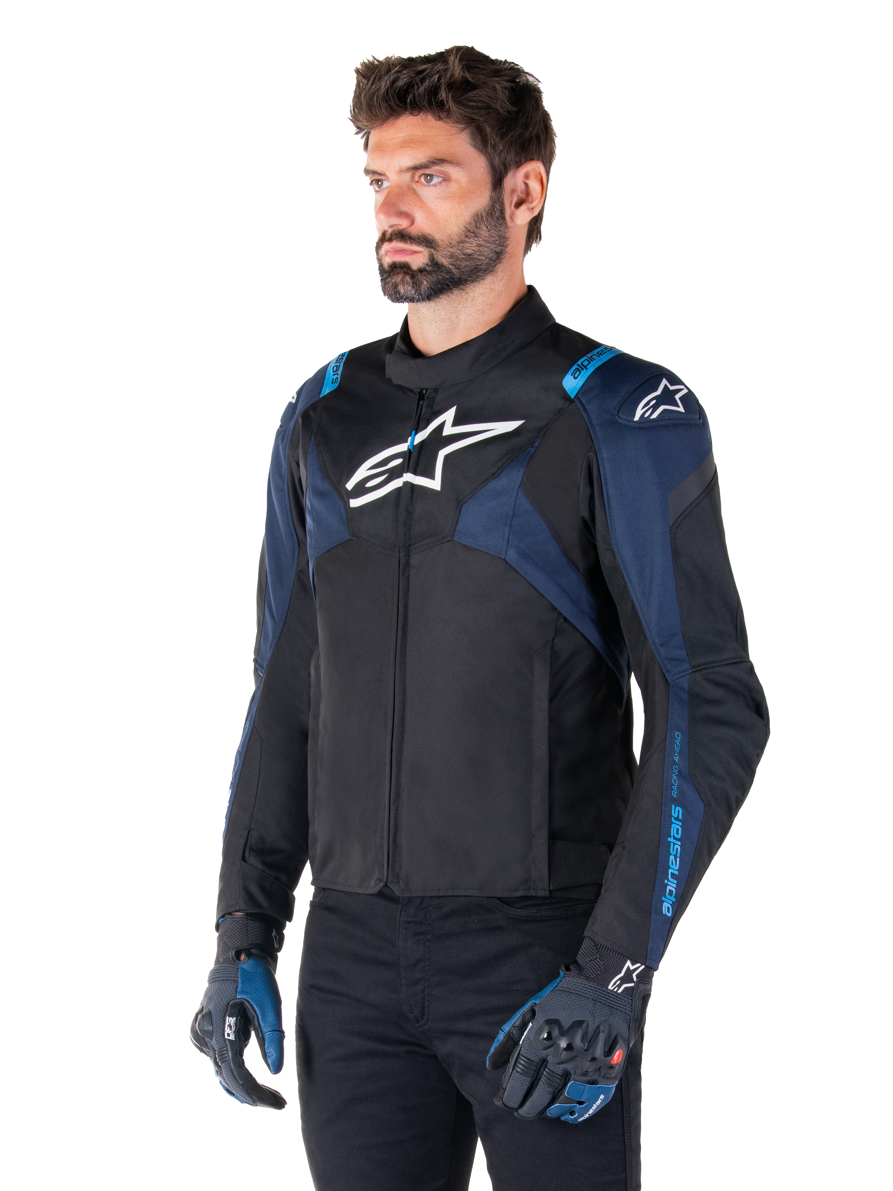 Alpinestars T-Jaws V4 Waterproof Jacket, giacca da moto, nero, blu scuro e blu Blithe, indossata da un modello con guanti coordinati e pantaloni neri, con loghi Alpinestars bianchi su petto e spalle e dettagli blu sulle maniche, abbigliamento tecnico sportivo in tessuto