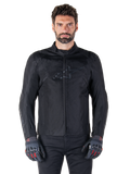 Giacca Alpinestars T-SPS V2 Waterproof, giacca da moto in tessuto nero, indossata da un pilota con guanti neri e rossi, dotata di colletto alto, zip frontale e logo discreto sul petto, protezione impermeabile per guida sportiva e urbana