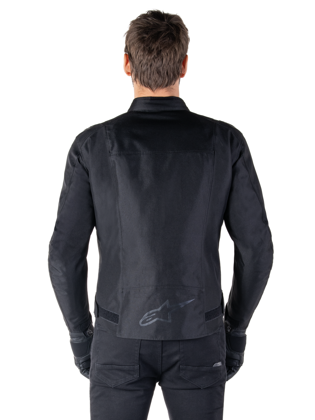Giacca Alpinestars T-SPS V2 Waterproof, nero, vista posteriore con silhouette dal taglio sportivo, logo Alpinestars riflettente sulla parte bassa della schiena e parte posteriore allungata per una maggiore copertura durante la guida.