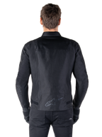 Giacca Alpinestars T-SPS V2 Waterproof, nero, vista posteriore con silhouette dal taglio sportivo, logo Alpinestars riflettente sulla parte bassa della schiena e parte posteriore allungata per una maggiore copertura durante la guida.