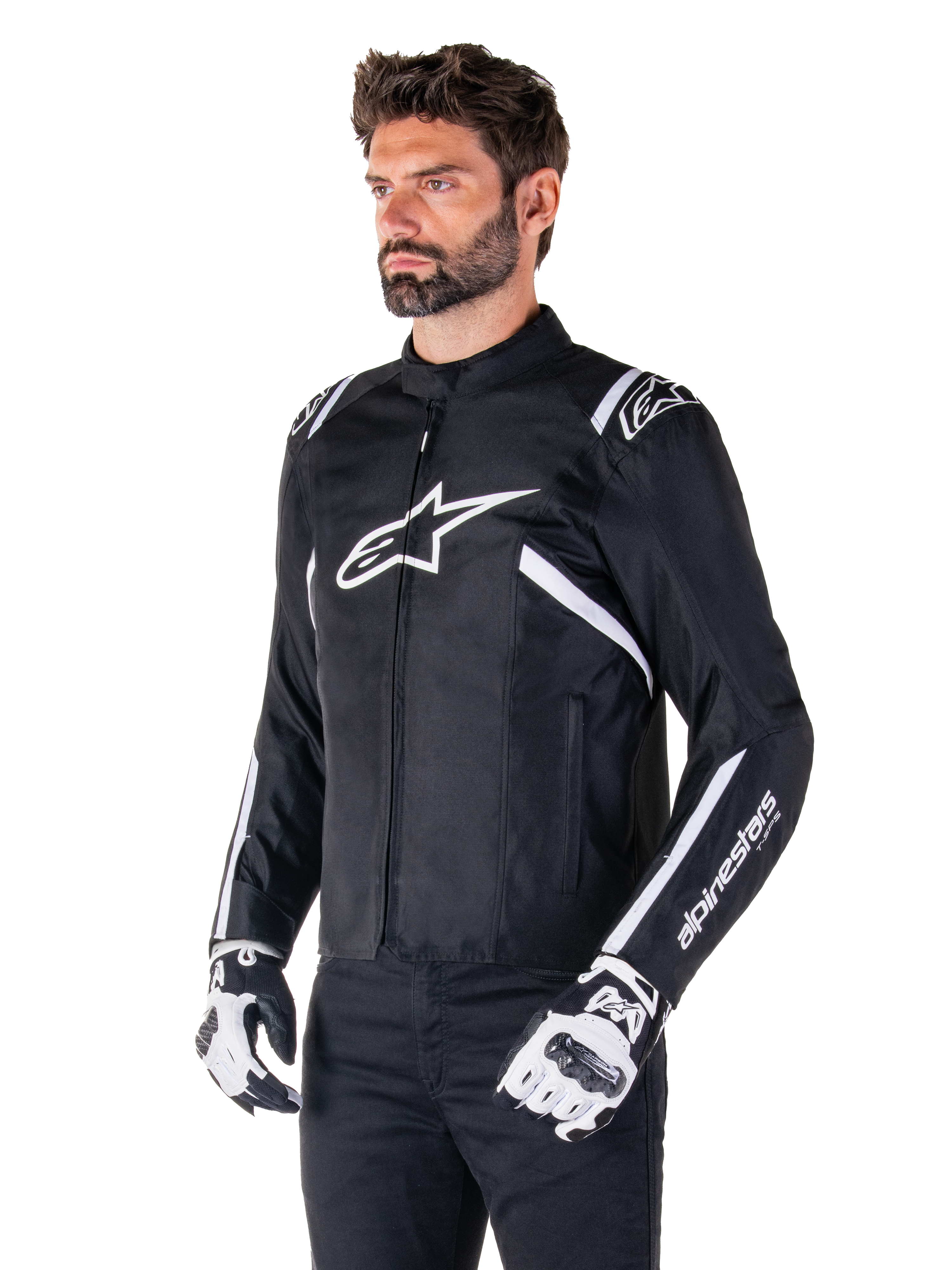 Giacca Alpinestars T-SPS V2 Waterproof, nero e bianco, indossata da un modello con guanti da moto coordinati, giacca in tessuto dal taglio sportivo con loghi Alpinestars bianchi su petto e spalle, marchio 'alpinestars T-SPS' sulla manica, abbigliamento da moto elegante d'ispirazione racing
