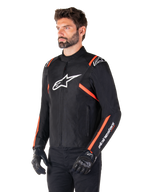 Giacca Alpinestars T-SPS V2 Waterproof, nero, bianco e rosso fluo, indossata da un modello con guanti e pantaloni neri, con un logo Alpinestars bianco sul petto e accenti rosso fluo su spalle e maniche, design sportivo in tessuto