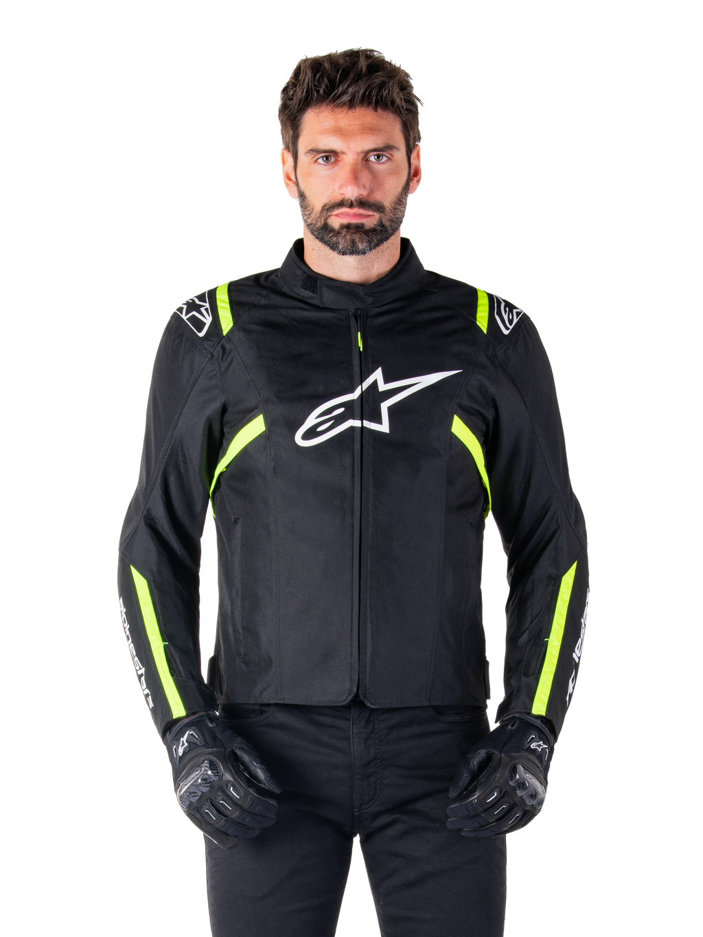 Alpinestars T-SPS V2 Waterproof Jacket, giacca da moto, nero con accenti bianco e giallo fluo, indossata da un modello con guanti neri, con logo a stella bianco sul petto e strisce giallo neon su maniche e spalle, abbigliamento sportivo in tessuto per ogni condizione climatica