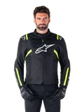 Alpinestars T-SPS V2 Waterproof Jacket, giacca da moto, nero con accenti bianco e giallo fluo, indossata da un modello con guanti neri, con logo a stella bianco sul petto e strisce giallo neon su maniche e spalle, abbigliamento sportivo in tessuto per ogni condizione climatica