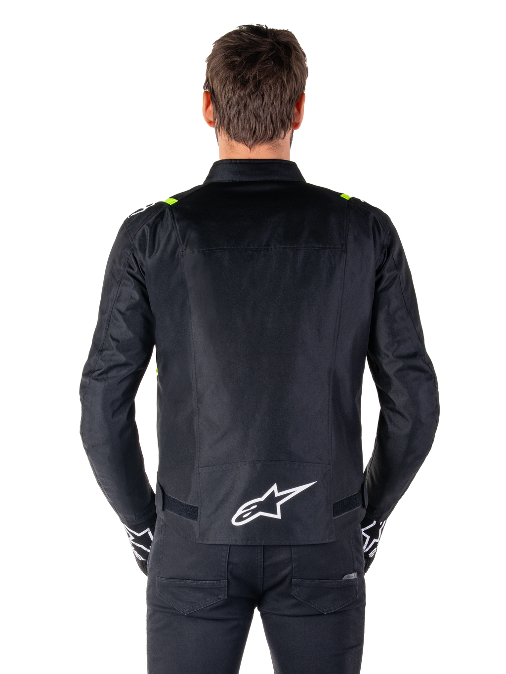 Giacca Alpinestars T-SPS V2 Waterproof, vista posteriore, nero con accenti giallo fluo sulle spalle e logo a stella bianco sulla parte bassa della schiena, giacca da moto in tessuto con silhouette sportiva, indossata da un modello maschile