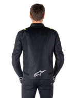 Giacca Alpinestars T-SPS V2 Waterproof, vista posteriore, nero con accenti giallo fluo sulle spalle e logo a stella bianco sulla parte bassa della schiena, giacca da moto in tessuto con silhouette sportiva, indossata da un modello maschile