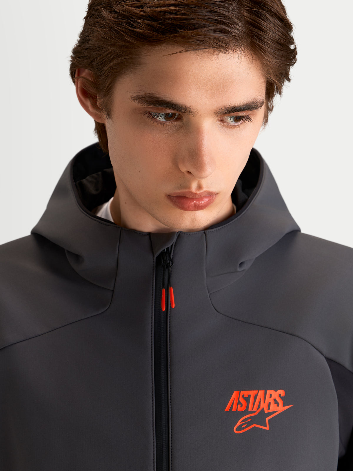 Alpinestars Aeroshell WP Giacca, giacca da moto sportiva softshell da uomo, nero e grigio scuro, con cappuccio e logo ASTARS arancione, primo piano sul modello