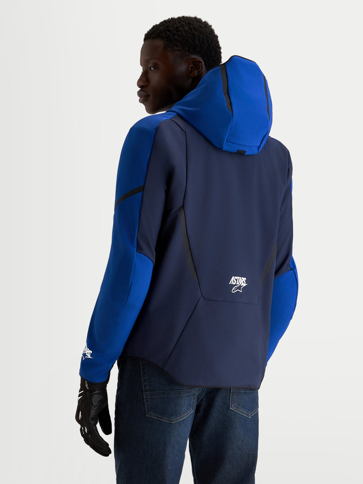 Alpinestars Aeroshell Wp Giacca, giacca da moto impermeabile sportiva in softshell da uomo, blu scuro e blu brillante con cappuccio, vista posteriore su modello che indossa guanti da moto