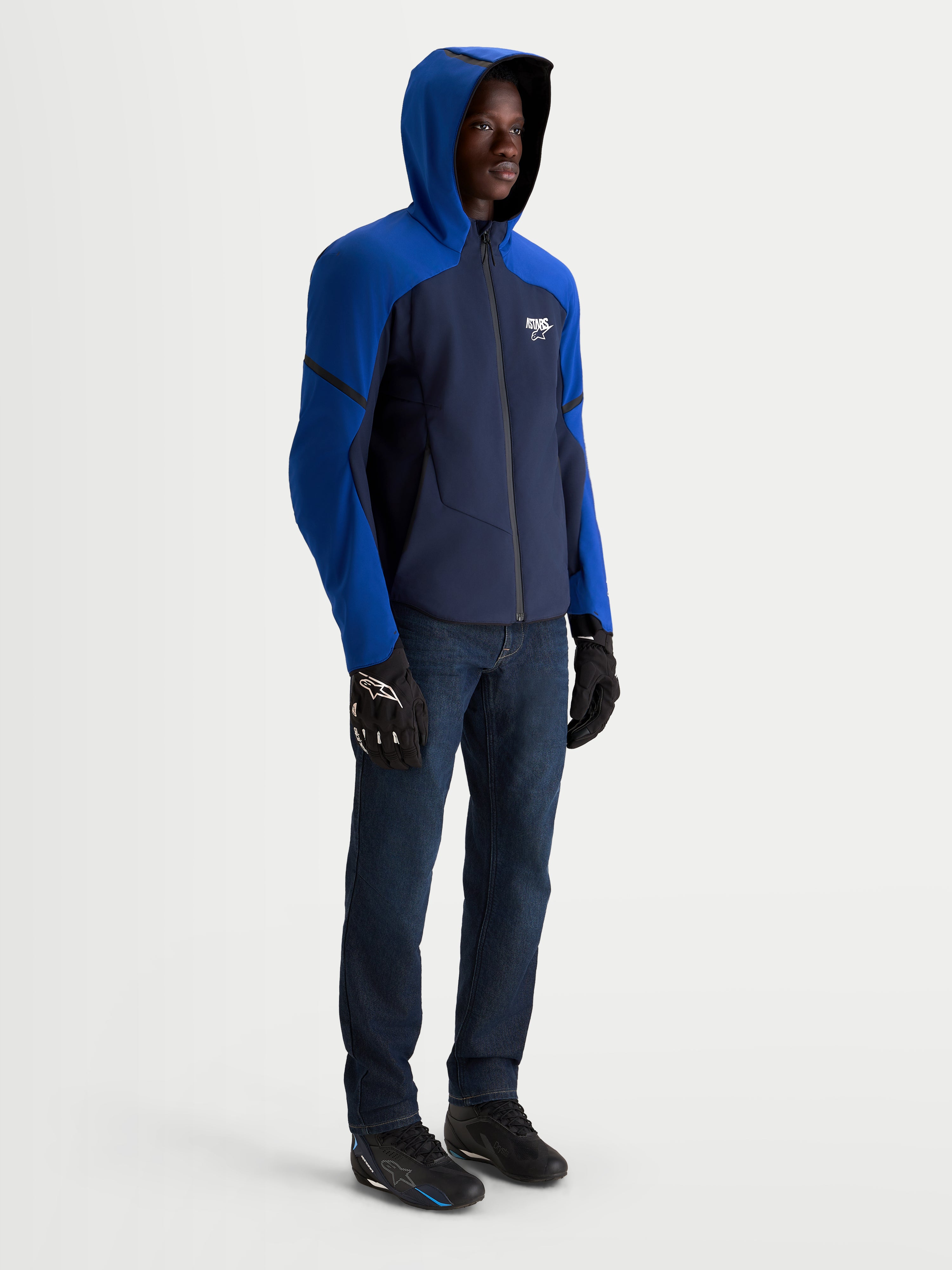 Alpinestars Aeroshell Wp Giacca, giacca da moto sportiva con cappuccio indossata da un modello, blu scuro e blu brillante, impermeabile in tessuto elasticizzato, vista laterale