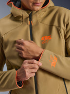 Giacca Alpinestars Aeroshell Waterproof, Dark Khaki e Arancione Fluo, primo piano della parte anteriore e della manica con loghi ASTARS arancioni, profili arancioni su cappuccio e polsini e cerniera impermeabile nera.