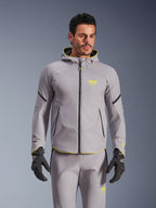 Giacca Alpinestars Aeroshell Waterproof, grigio medio e giallo fluo, giacca da moto softshell con cappuccio e cerniere nere, indossata con pantaloni grigi coordinati e guanti neri, abbigliamento tecnico impermeabile per guida su strada