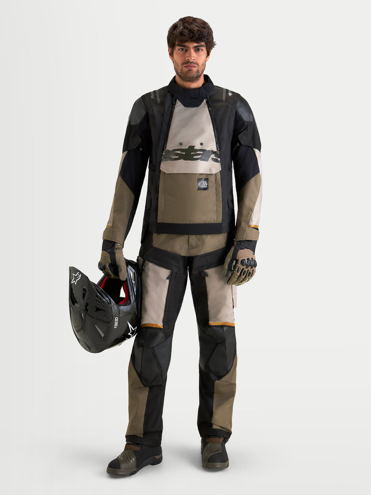 Alpinestars Harok V2 Drystar Giacca, giacca da moto adventure all-terrain da uomo in alluminio, marrone e nero, indossata con equipaggiamento adventure coordinato mentre si tiene un casco