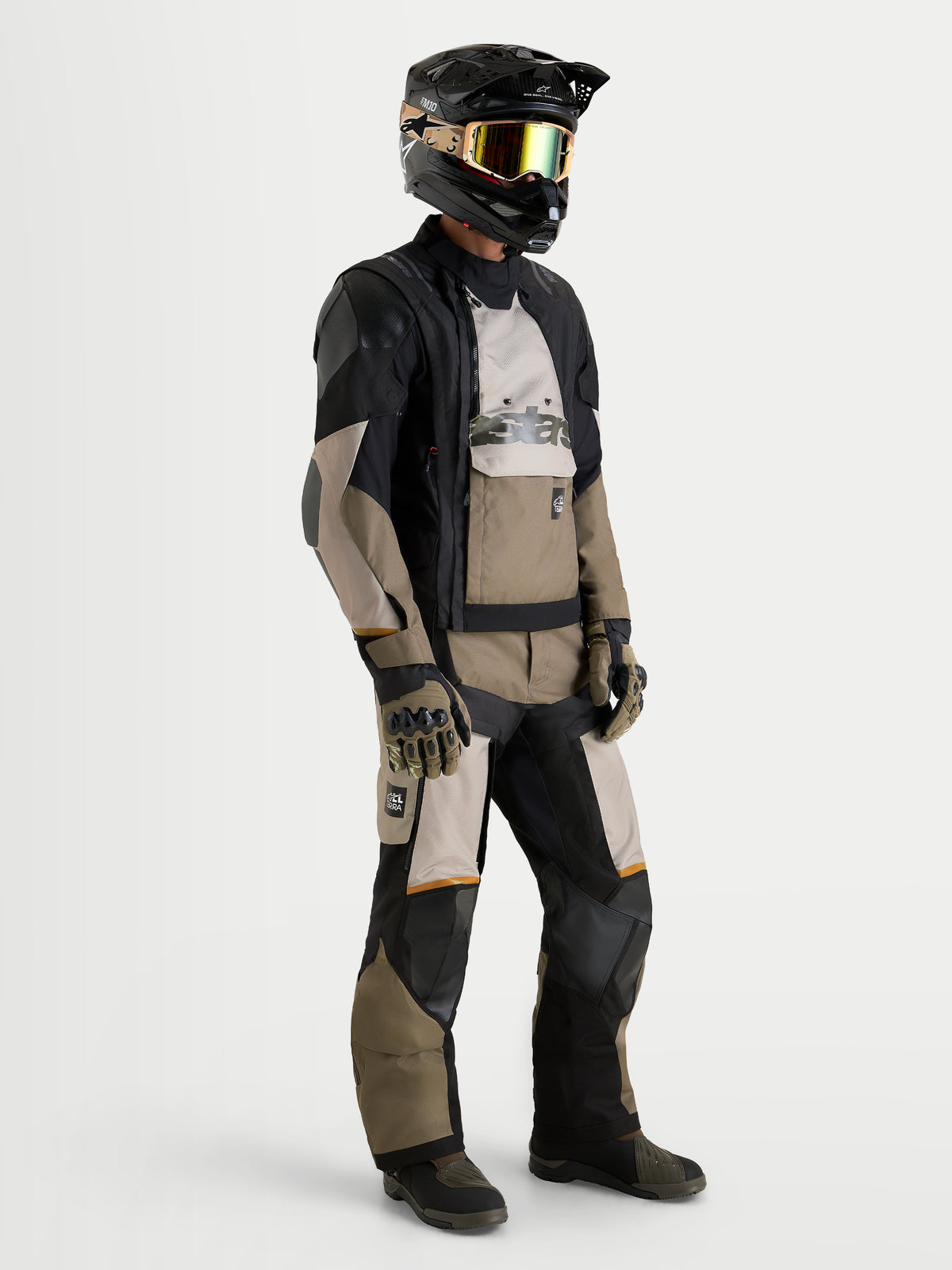 Alpinestars Harok V2 Drystar Giacca, giacca da moto all-terrain adventure da uomo in alluminio, marrone e nero, indossata da un pilota con casco e pantaloni abbinati