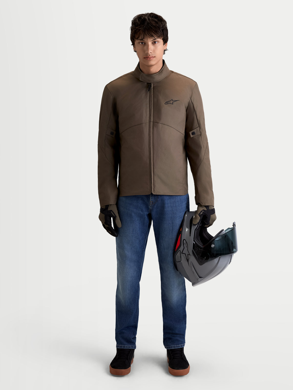 Alpinestars C 1 Waterproof Giacca, giacca da moto urbana contemporanea da uomo in marrone noce e nero, vista frontale su un modello che indossa la giacca e tiene un casco