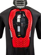 Sistema Airbag Alpinestars Tech-Air 5 Plasma, vista interna che mostra la bomboletta di ricambio nera e l'unità di controllo elettronica, integrati in un paraschiena Nucleon Plasma rosso brillante all'interno di un gilet protettivo nero