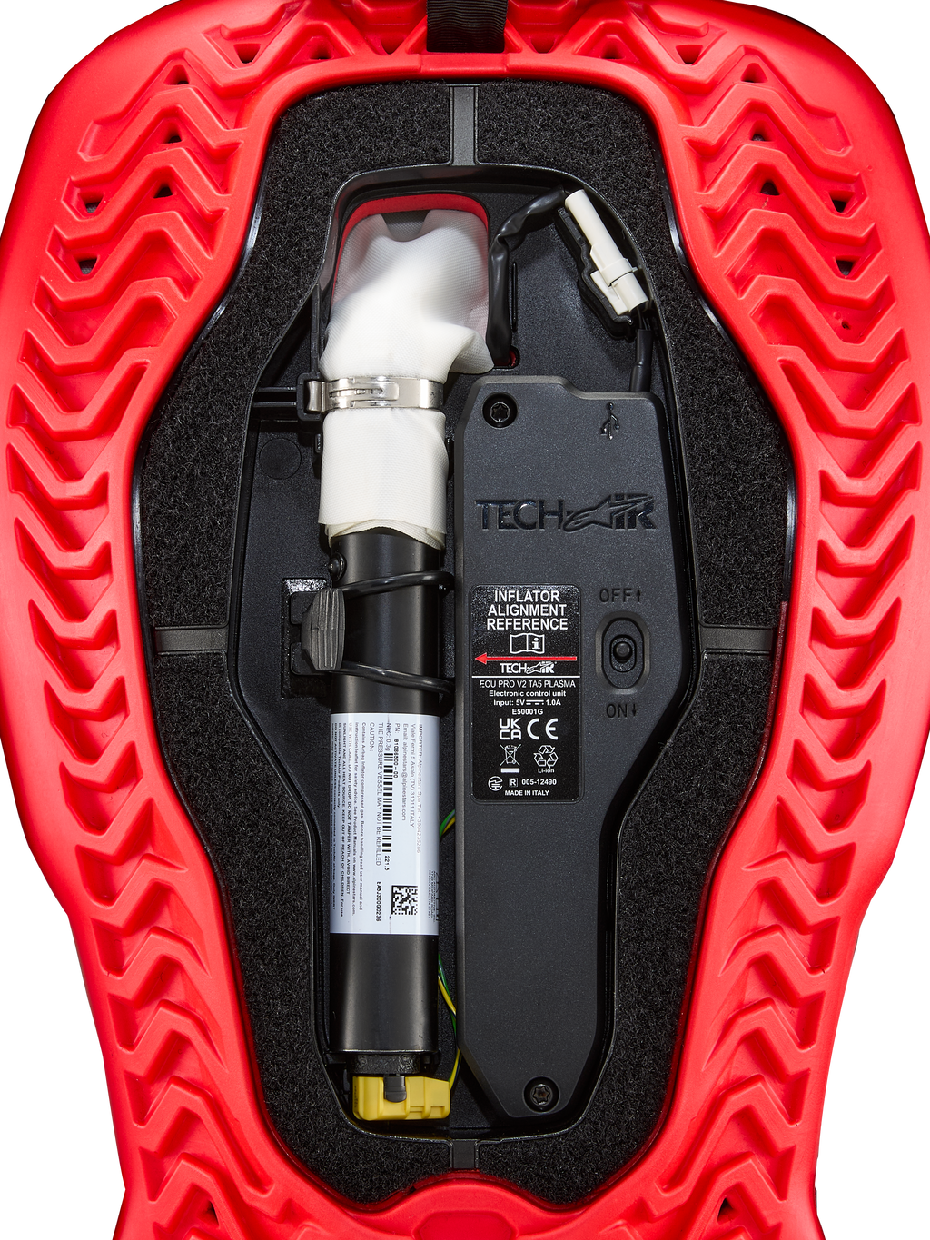 Alpinestars Tech-Air® 5 Plasma, cartuccia di ricambio per airbag, accessorio per sistema airbag, rosso e nero, vista interna ravvicinata che mostra la bomboletta bianca del gonfiatore ad argon con morsetto argentato, unità di controllo elettronica con interruttore ON/OFF e guscio esterno rosso con coste ondulate
