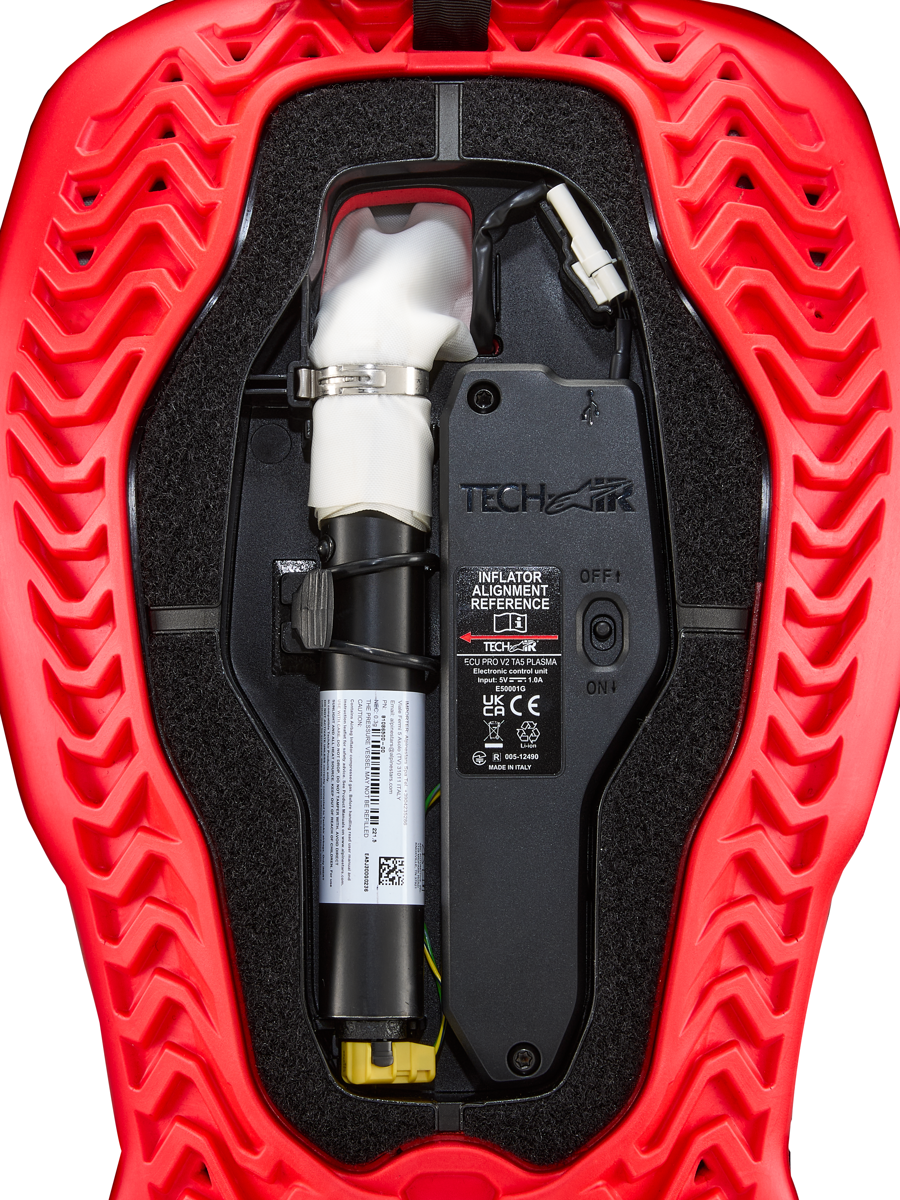 Alpinestars Tech-Air® 5 Plasma, cartuccia di ricambio per airbag, accessorio per sistema airbag, rosso e nero, vista interna ravvicinata che mostra la bomboletta bianca del gonfiatore ad argon con morsetto argentato, unità di controllo elettronica con interruttore ON/OFF e guscio esterno rosso con coste ondulate