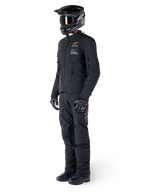 Alpinestars AMT-8 Stretch Drystar® XF Jacket, giacca da moto adventure, nero, indossata con pantaloni coordinati, casco e guanti, con marchio Alpinestars Motion Technology e accenti arancioni, struttura elasticizzata resistente per la guida adventure