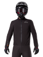 Alpinestars AMT-8 Stretch Drystar® XF Liner, fodera impermeabile da moto nera, dotata di cerniera anteriore e vita elasticizzata, logo AMT sul petto e branding Drystar XF sulla manica, indossata con casco e guanti neri.
