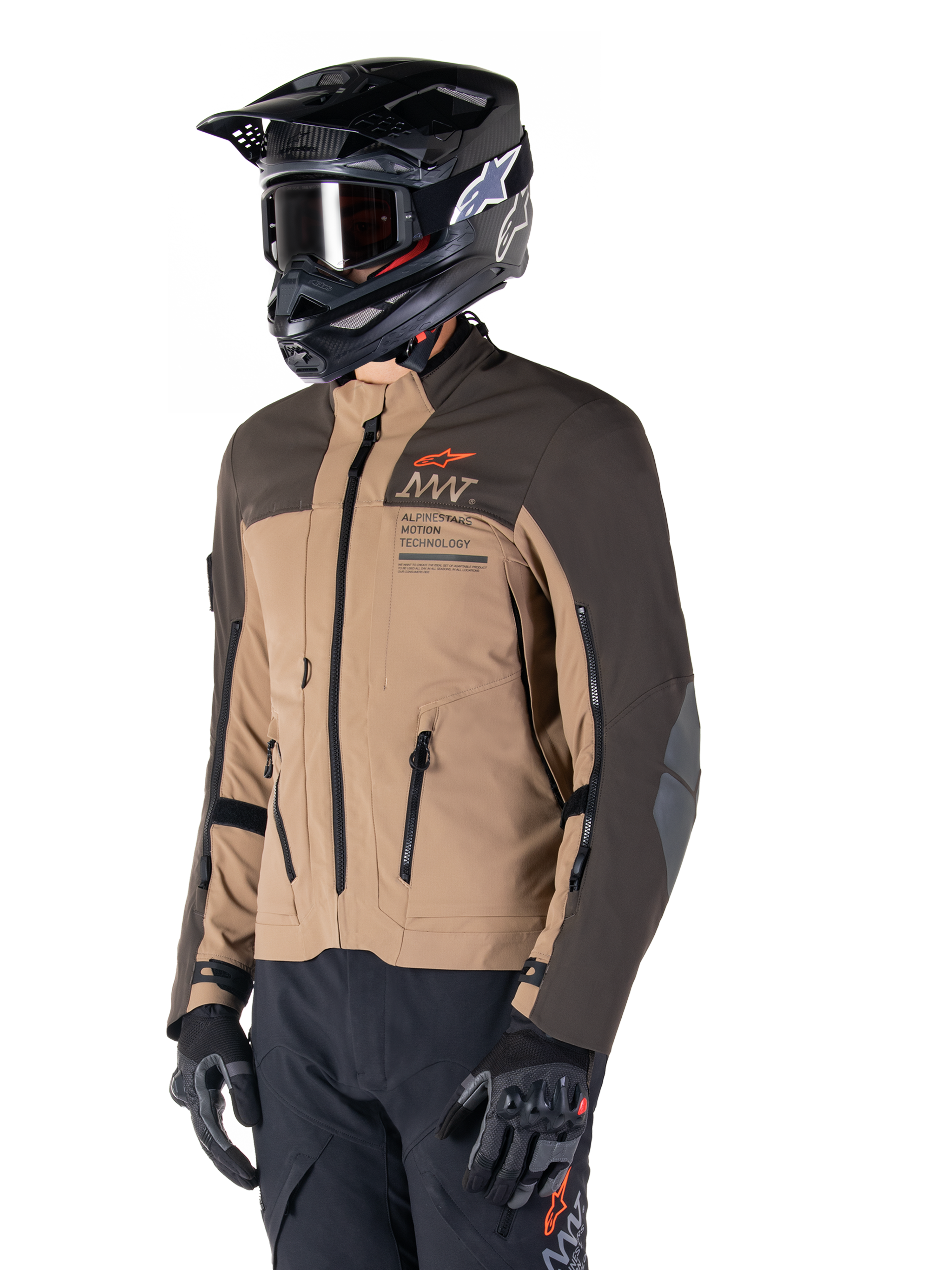 Giacca Alpinestars AMT-8 Stretch Drystar® XF, giacca da moto adventure, marrone scuro e dark khaki, indossata con casco off-road nero e maschera, con logo Alpinestars Motion Technology e prese d'aria con cerniera.