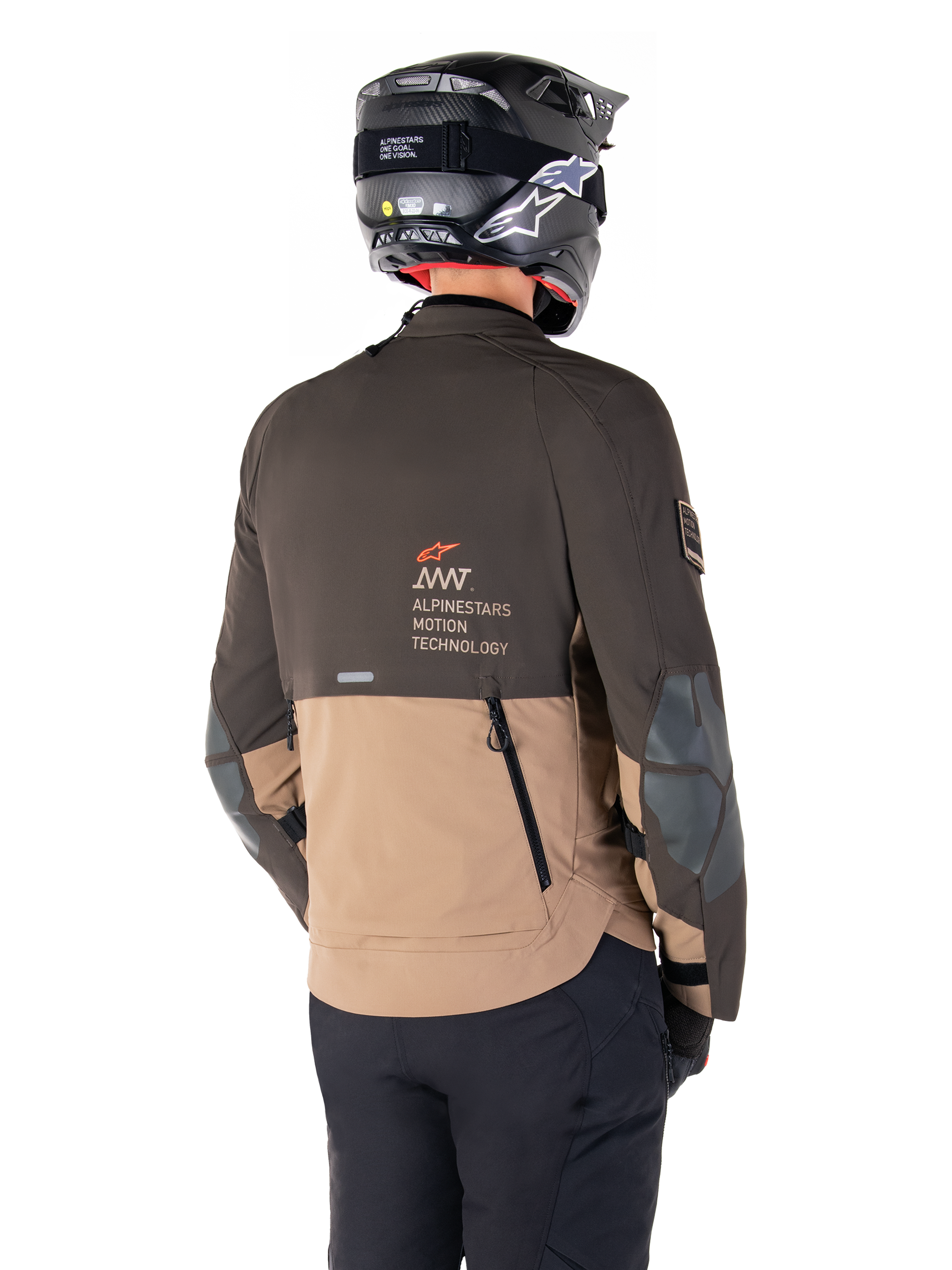 Giacca Alpinestars AMT-8 Stretch Drystar® XF, giacca da moto Adventure, marrone scuro e kaki scuro, vista posteriore con branding AMT Alpinestars Motion Technology, design in tessuto bicolore con cerniere di ventilazione posteriori e sfiato a tegola, indossata con casco e pantaloni da guida neri