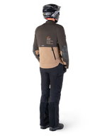 Giacca Alpinestars AMT-8 Stretch Drystar® XF, giacca da moto adventure touring, marrone scuro e dark khaki, vista posteriore con marchio 'AMT Alpinestars Motion Technology', indossata con pantaloni neri e casco, design ergonomico elasticizzato per la guida adventure