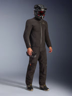 Giacca Alpinestars AMT-8 Stretch Drystar® XF in nero, indossata come parte di un kit da moto completo con pantaloni coordinati e casco nero, caratterizzata da un design in tessuto elegante con logo Drystar XF arancione sulla manica, ideale per l'adventure touring.