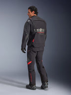 Giacca laminata Alpinestars Halo Pro Drystar® XF, giacca da moto adventure, Black Dark Shadow con accenti rossi, vista posteriore indossata con pantaloni e stivali coordinati, con logo grigio sulla schiena, design tessile modulare per adventure touring
