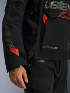 Alpinestars Halo Pro Drystar® XF Laminated Jacket, giacca da moto, nera con accenti rossi, primo piano con marchio Drystar® XF, texture tecnica del guscio laminato e dettagli regolabili sulle maniche per guida adventure
