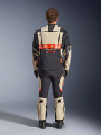 Giacca laminata Alpinestars Halo Pro Drystar® XF, giacca da moto adventure, Mastic Black con logo arancione, vista posteriore che mostra il grande marchio sulla schiena e le cerniere di ventilazione modulari, indossata con pantaloni adventure coordinati per prestazioni su ogni terreno