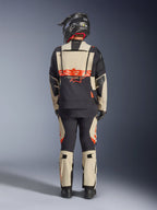 Giacca laminata Alpinestars Halo Pro Drystar® XF, giacca da moto adventure, Mastic Black, vista posteriore di un pilota che indossa pantaloni coordinati e un casco nero, con branding Alpinestars arancione acceso e pannelli di ventilazione modulari per una guida adventure versatile.