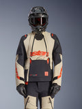 Alpinestars Halo Pro Drystar XF Laminated Jacket, giacca da moto adventure in Mastic Black e beige con accenti rossi, indossata con equipaggiamento protettivo completo inclusi casco e guanti, dotata di pannelli di ventilazione modulari e costruzione laminata 3L.