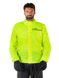 Alpinestars Hurricane Rain V2 Jacket, giacca antipioggia da moto, giallo fluo, indossata da un modello con pantaloni e guanti neri, colletto alto con linguette riflettenti, patta protettiva anteriore con logo Alpinestars, abbigliamento impermeabile ad alta visibilità