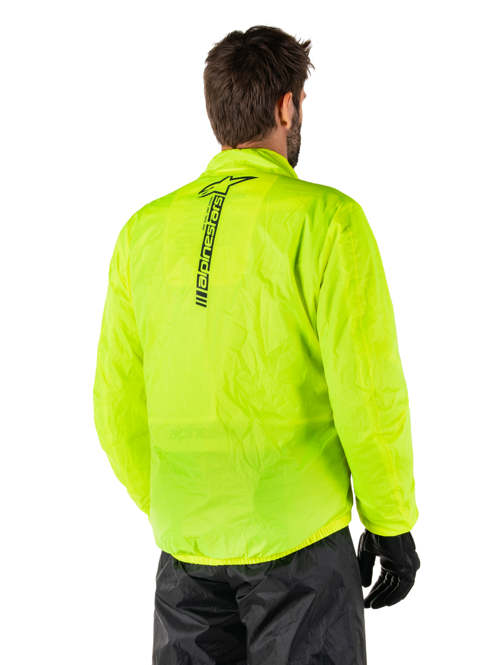 Giacca Alpinestars Hurricane Rain V2, Giallo Fluo, vista posteriore indossata da modello maschile, con marchio Alpinestars verticale nero al centro della schiena, vita e polsini elasticizzati, design impermeabile e ripiegabile