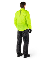 Persona vista di schiena che indossa la giacca Alpinestars Hurricane Rain V2 in Giallo Fluo e i pantaloni Hurricane Rain V2 neri, logo verticale sul retro della giacca, abbigliamento antipioggia impermeabile da moto con guanti e stivali neri