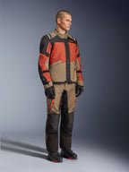 Alpinestars Andes V4 Drystar® Jacket, giacca adventure touring, Walnut Rust Black, indossata con pantaloni coordinati e stivali neri, caratterizzata da un design a blocchi di colore beige, ruggine e nero, robusta costruzione in tessuto con cerniere a vista e loghi Alpinestars.