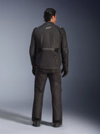 Vista posteriore di un pilota che indossa la giacca Alpinestars Andes V4 Drystar® in nero, abbinata a pantaloni e guanti da moto coordinati, con logo e scritta Alpinestars sulla schiena, abbigliamento tecnico adventure per ogni condizione atmosferica