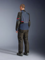 Alpinestars Andes V4 Drystar® Jacket, giacca da moto in Night Navy e Mood Indigo con pannelli neri e accenti rossi, vista posteriore di tre quarti, indossata con pantaloni da moto adventure neri e stivali, costruzione in tessuto tecnico con logo Alpinestars sulla schiena, orlo posteriore allungato.