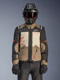 Giacca Alpinestars Andes V4 Drystar®, Walnut Mastic Black, giacca da adventure touring con pannelli marrone noce e crema mastice, maniche nere e accenti arancione vivace, indossata con casco da moto nero, occhiali scuri e guanti neri