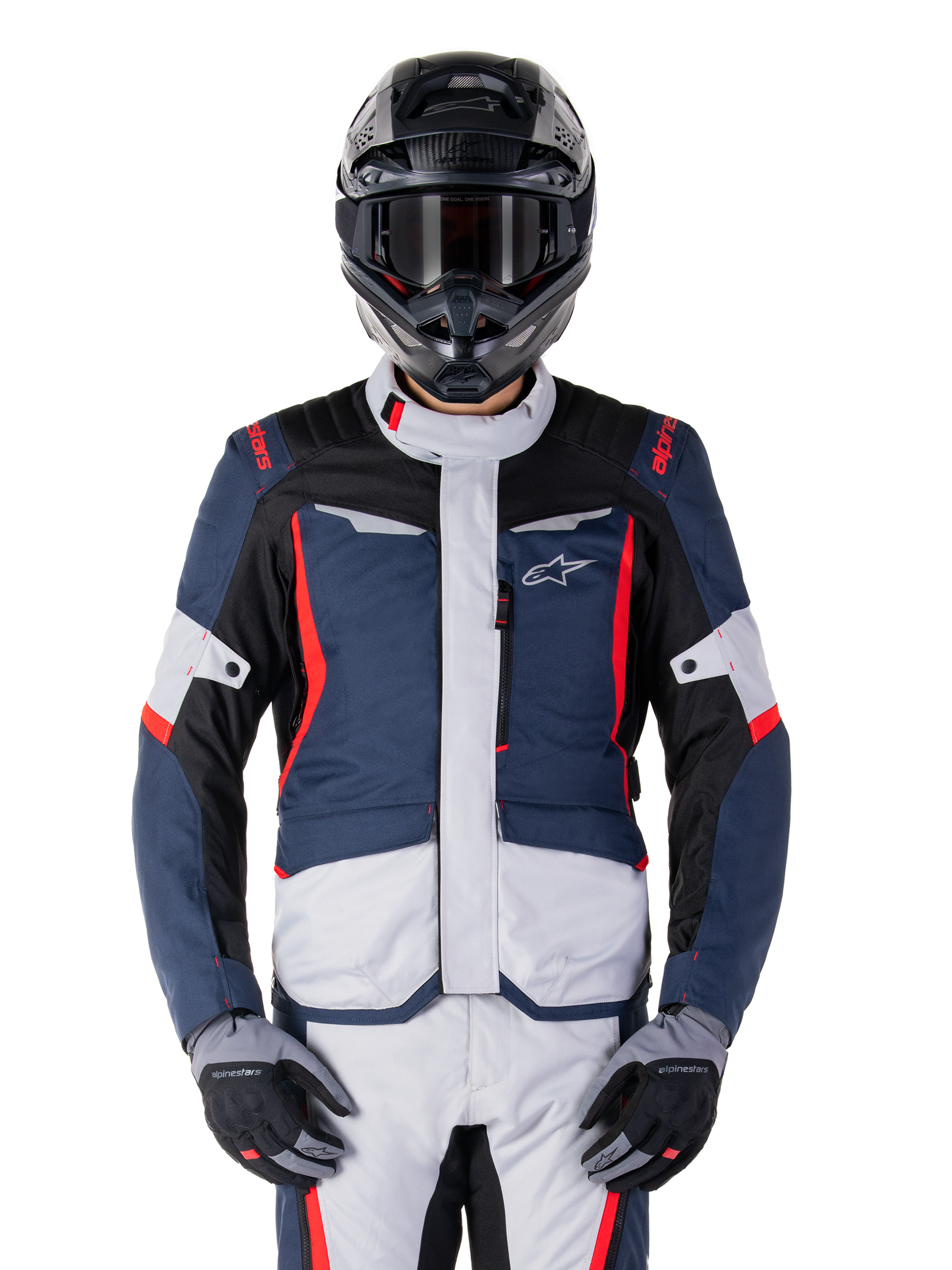 Giacca Alpinestars ST-1 Waterproof, giacca da adventure touring, blu scuro, nero e rosso brillante, indossata con casco adventure nero e guanti grigi, pannelli grigio chiaro e accenti rossi su spalle e cerniere, design elegante con logo Alpinestars sul petto, abbigliamento impermeabile resistente per la guida in moto