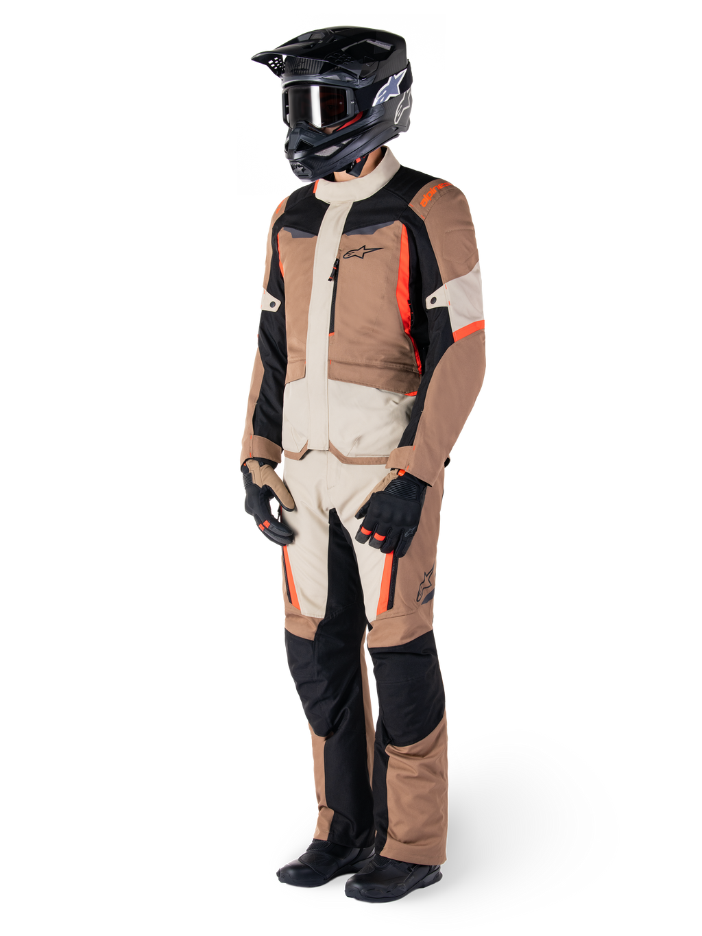 Giacca Alpinestars ST-1 Waterproof, Dark Khaki Sand Nero Rosso Fluo, indossata da un pilota con equipaggiamento completo da adventure touring, pantaloni coordinati, casco nero, occhiali, guanti e stivali, completo tecnico da moto per ogni condizione atmosferica