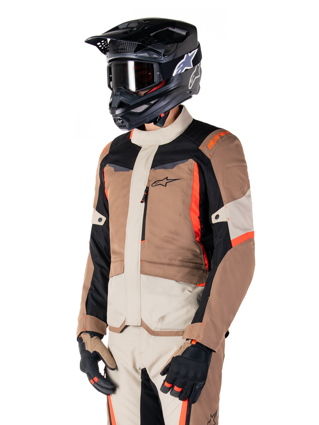 Giacca Alpinestars ST-1 Waterproof, giacca adventure touring, Dark Khaki Sand nero e rosso fluo, indossata da un pilota con casco da motocross nero e occhiali, caratterizzata da un design a pannelli con tasche cargo e branding Alpinestars sul petto