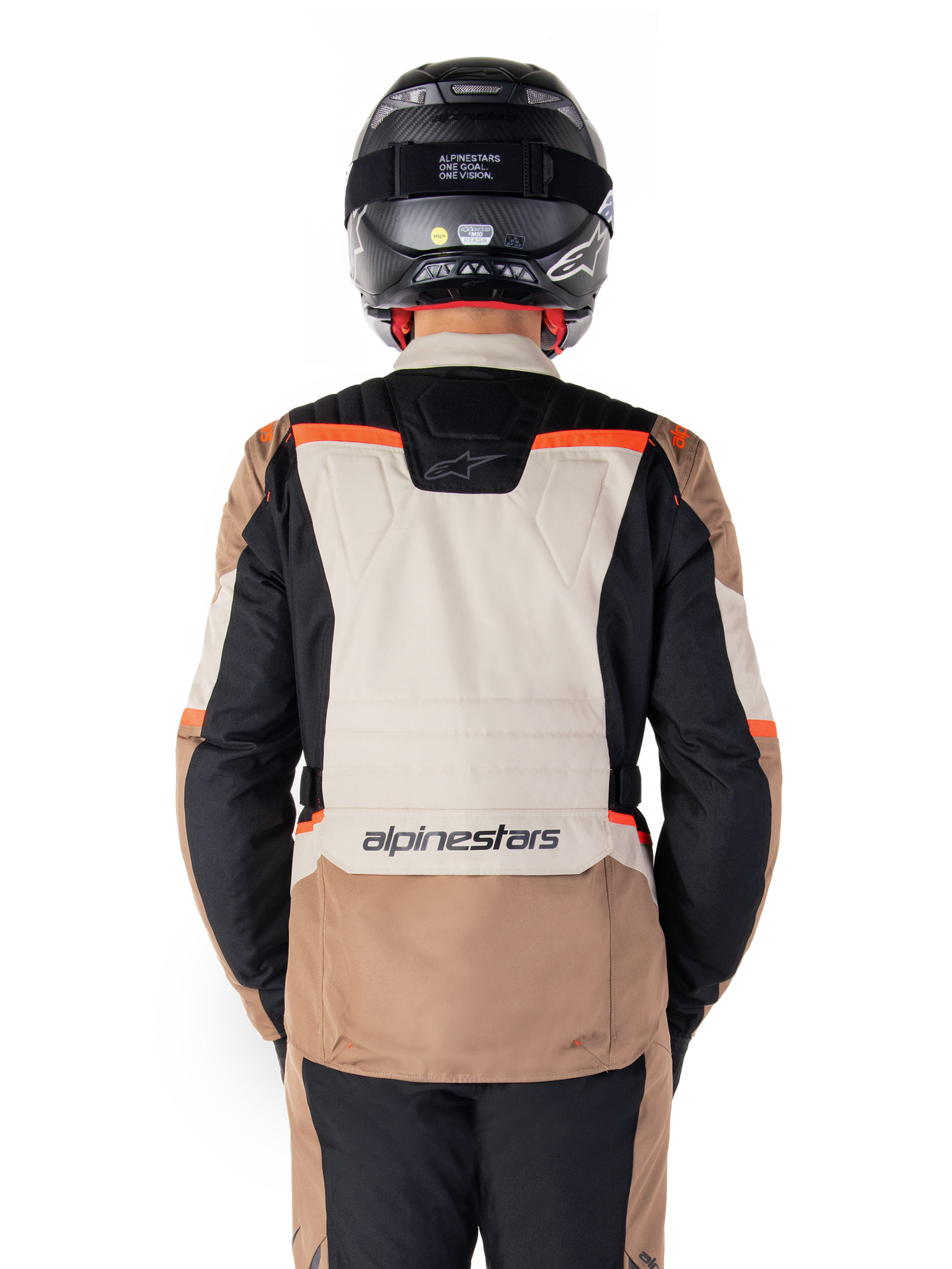 Giacca impermeabile Alpinestars ST-1, Dark Khaki Sand Black Red Fluo, vista posteriore, giacca da moto adventure touring con ampio pannello posteriore sabbia, maniche nere e accenti rosso fluorescente, indossata da un pilota con casco nero